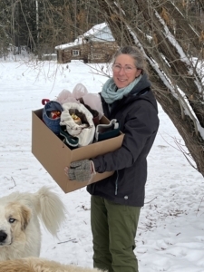 alt="Sherry Sinclair holding a box of donations for the stockings for seniors"