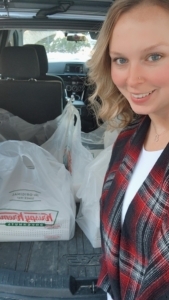 alt="Shannon Owen with bags of baked goods for first responders in back of vehicle"
